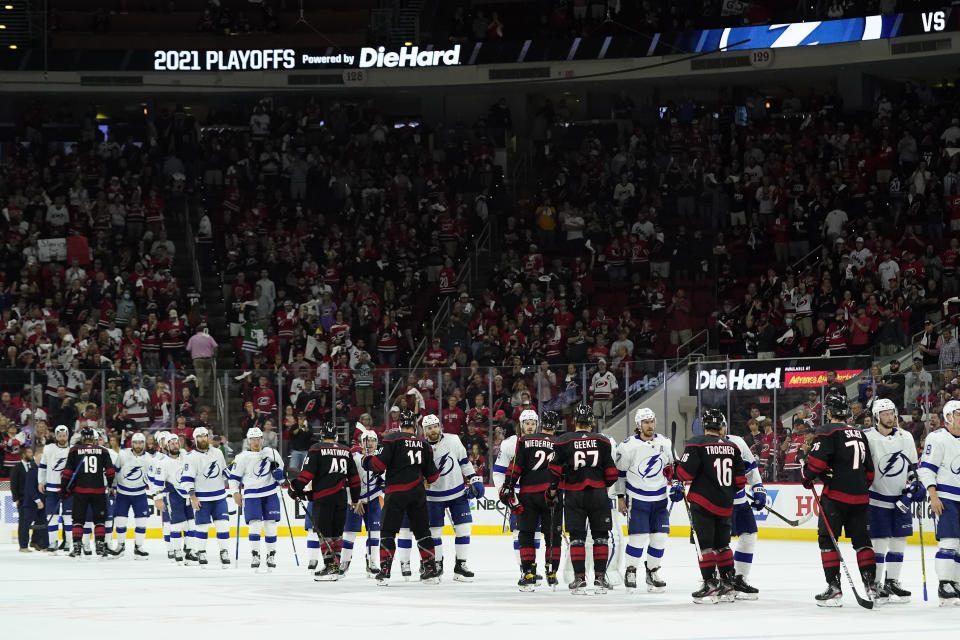 Carolina Hurricanes players and Tampa Bay Lightning players speak with each other following Game 5 of an NHL hockey Stanley Cup second-round playoff series in Raleigh, N.C., Tuesday, June 8, 2021. (AP Photo/Gerry Broome)