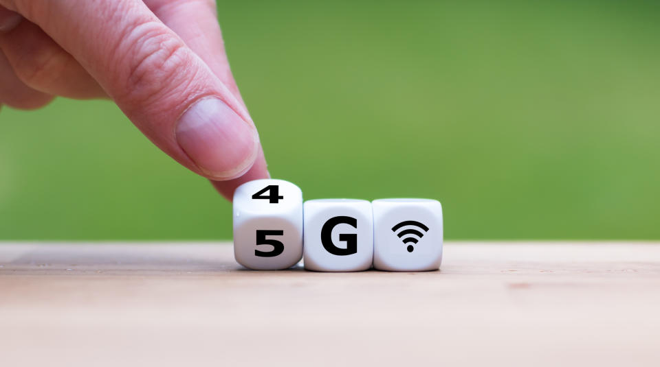 A man turns over a die from "4G" to "5G".