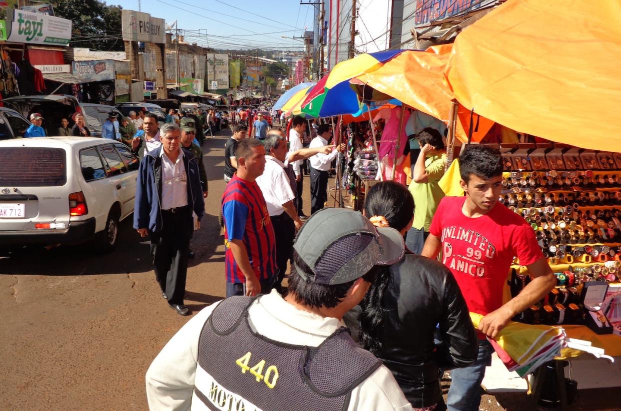 Vendors at work on a bustling Ciudad del Este street packed with stalls. Jennifer L. Tucker, <a href="http://creativecommons.org/licenses/by-nd/4.0/" rel="nofollow noopener" target="_blank" data-ylk="slk:CC BY-ND;elm:context_link;itc:0;sec:content-canvas" class="link ">CC BY-ND</a>