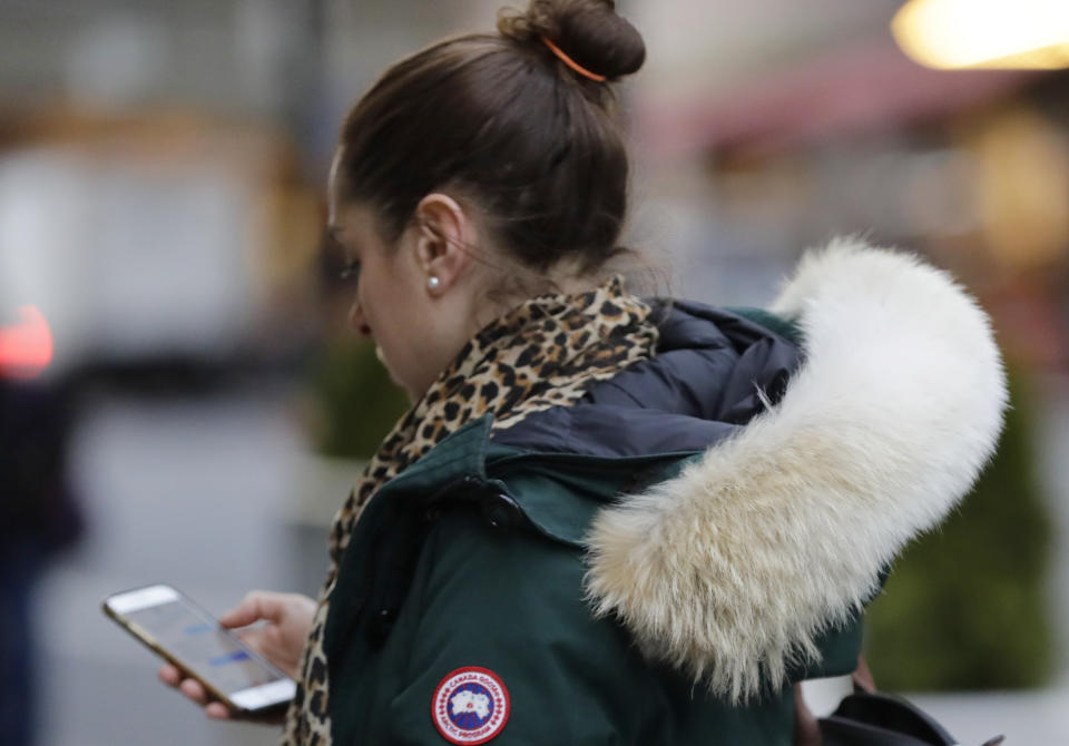 In this Feb. 14, 2019 photo, a woman in New York wears a Canada Goose coat with the hood trimmed in coyote fur. The fur-trimmed parkas so common on city sidewalks have become a boon to backwoods trappers. The rising demand for coyote fur is largely attributed to its use on Canada Goose parkas. (AP Photo/Frank Franklin II)