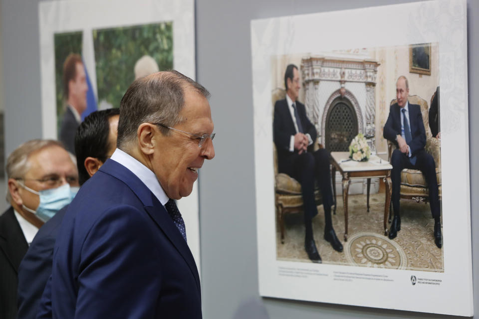 Russian Foreign Minister Sergey Lavrov looks at a photo showing the Russian President Vladimir Putin and the Cypriot president Nicos Anastasiades at the foreign ministry house in Nicosia, Cyprus, Tuesday, Sept. 8, 2020. Lavrov is paying an official visit to Cyprus amid heightened tensions over Turkey's search for energy resources in east Mediterranean waters where Greece and Cyprus claim as having exclusive economic rights. (AP Photo/Petros Karadjias)