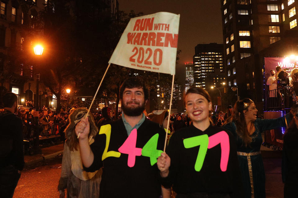 Revelers carrying political sign in support of Elizabeth Warren march during the 46th annual Village Halloween Parade in New York City. (Gordon Donovan/Yahoo News)