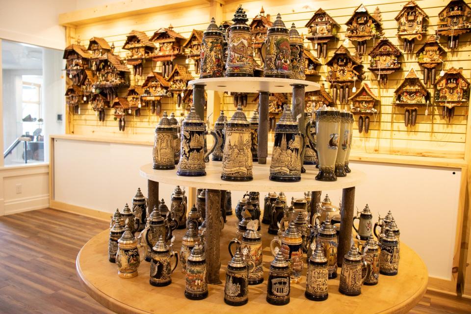 German cuckoo clocks on a wall behind a display of beer steins