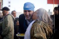 Leader of the Liberal Party of Canada MP Justin Trudeau gets a kiss from a woman in the downtown eastside neighbourhood in Vancouver, British Columbia December 18, 2013. REUTERS/Ben Nelms (CANADA - Tags: POLITICS)
