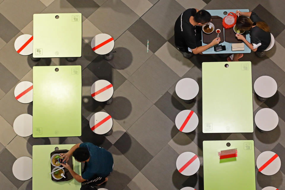 People dine on socially distanced table on December 7, 2021 in Singapore. (Photo by Suhaimi Abdullah/NurPhoto via Getty Images)