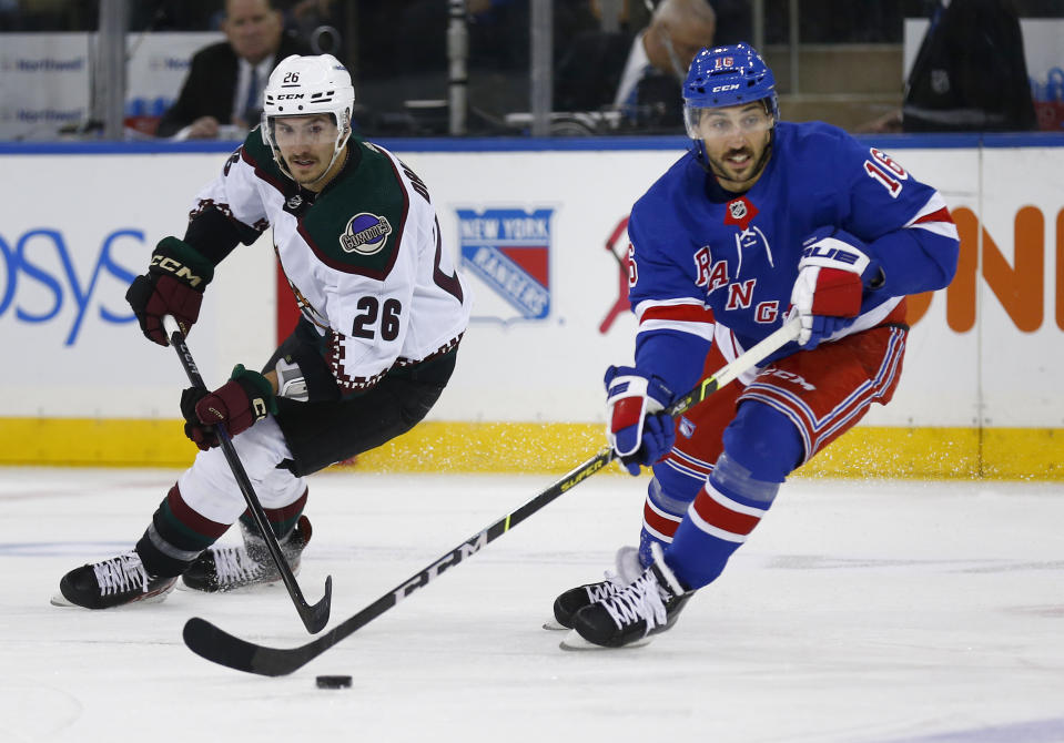 New York Rangers center Vincent Trocheck skates with the puck in front of Arizona Coyotes center Laurent Dauphin (26) during the first period of an NHL hockey game, Sunday, Nov. 13, 2022, in New York. (AP Photo/John Munson)