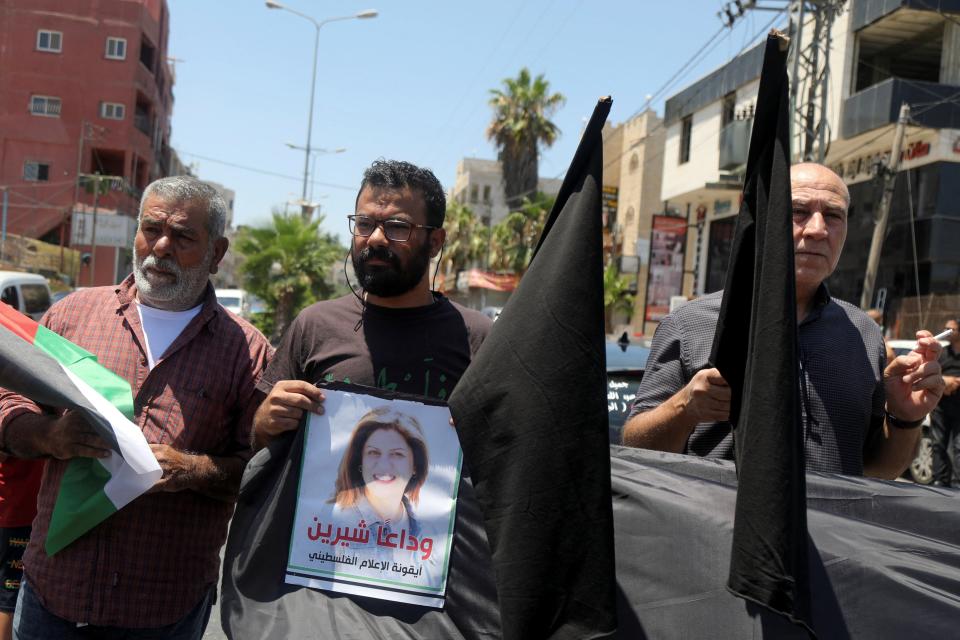 A protestor holds up a picture of slain Palestinian-American journalist Shireen Abu Akleh, as Palestinians demonstrate against the visit of US president Joe Biden to Bethlehem (Reuters)