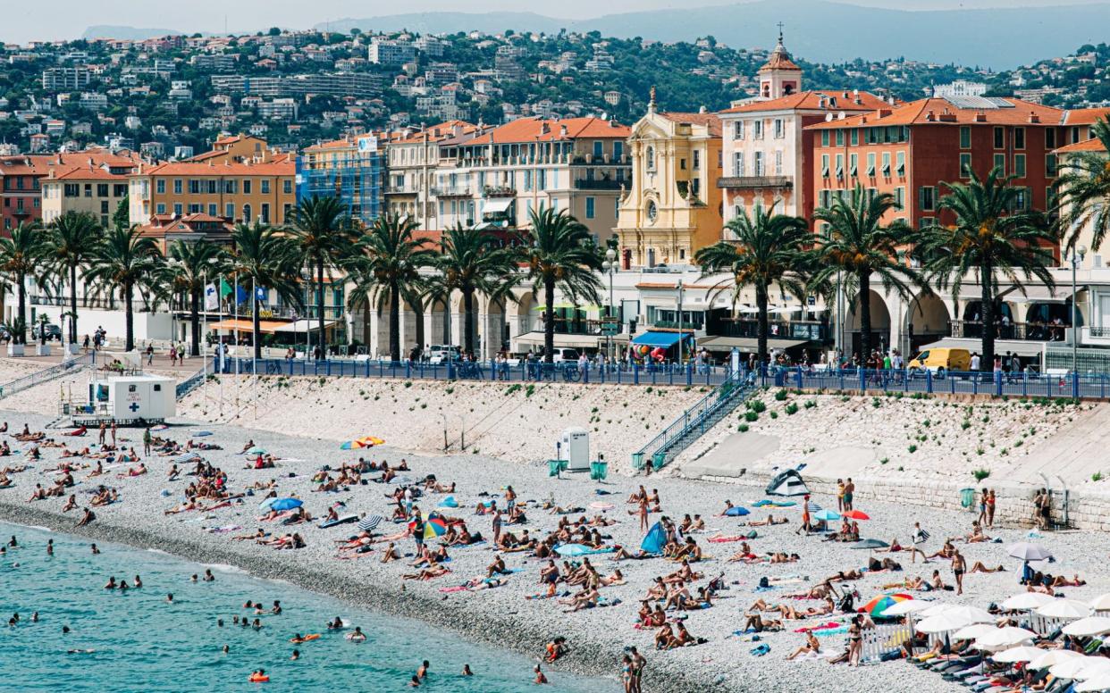 Nice beach with sunbathers and colourful buildings - Karl Hendon /Moment RF 