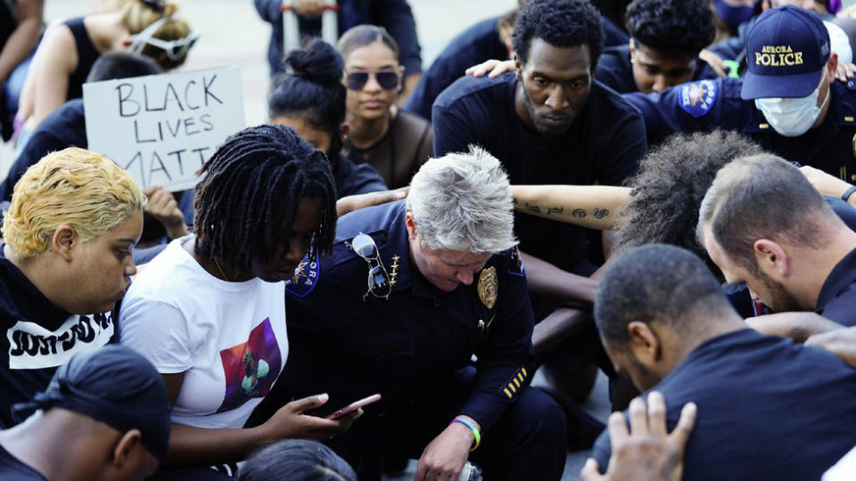 Protesters and police kneel together for eight minutes and 46 seconds during a peaceful protest against police brutality