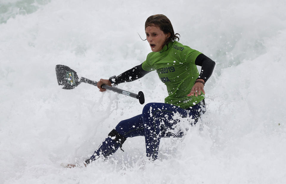 Brazil's Lena Guimaraes rides the surf to win the gold medal in the women's SUP race final during the Pan American Games on Punta Rocas beach in Lima Peru, Friday, Aug.2, 2019. (AP Photo/Silvia Izquierdo)