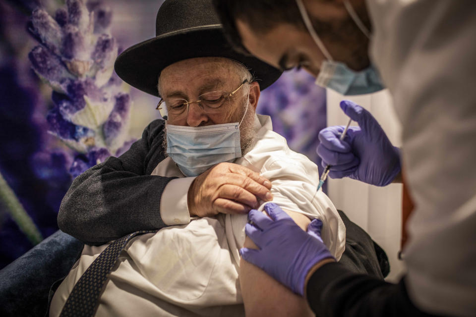 An Orthodox Jewish man receives his dose of the Pfizer-BioNTech COVID-19 vaccine at a vaccination center as a part of a nationwide campaign on 11 January 11, 2021. (Ilia Yefimovich/dpa via ZUMA Press)