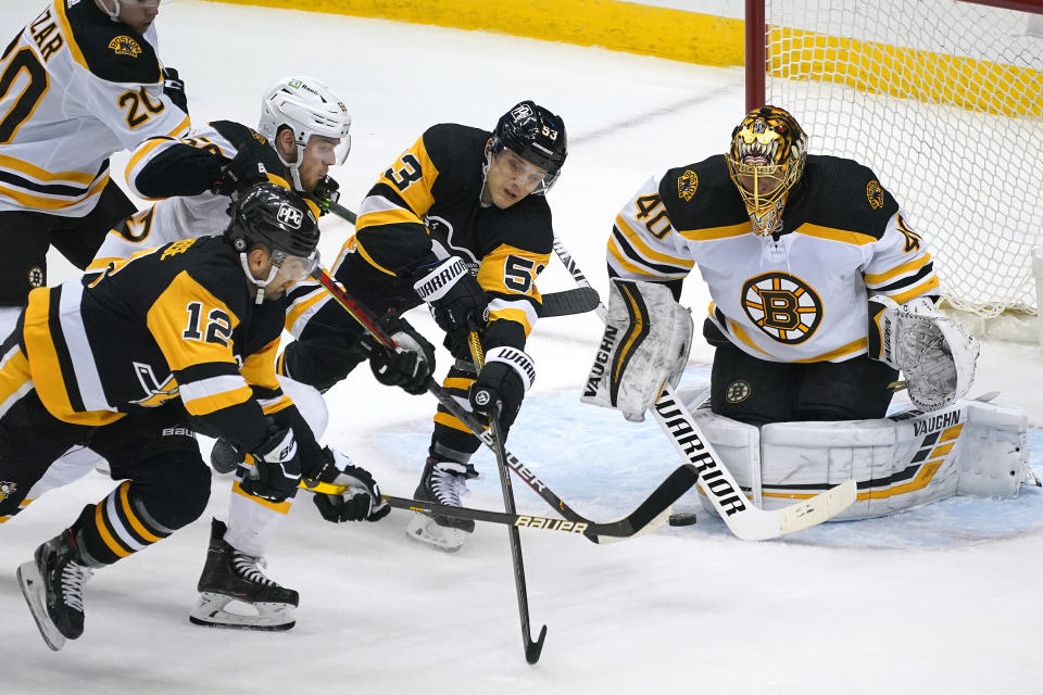 Pittsburgh Penguins' Zach Aston-Reese (12) gets off a shot in front of Boston Bruins goaltender Tuukka Rask (40) with Jeremy Lauzon (55) defending during the first period of an NHL hockey game in Pittsburgh, Tuesday, April 27, 2021.(AP Photo/Gene J. Puskar)