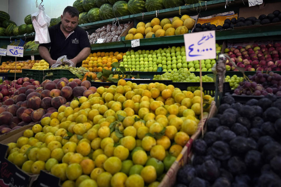 A worker rearranges fruits on display for sale at a shop in Beirut, Lebanon, Monday, July 15, 2022. In Lebanon, where endemic corruption and political stalemate has crippled the economy, the World Food Program is increasingly providing people with cash assistance to purchase food, particularly after the devastating 2020 port blast that destroyed massive grain silos. (AP Photo/Bilal Hussein)