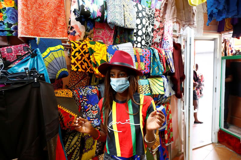 A woman poses poses inside an African clothing store of the Matonge district in Brussels