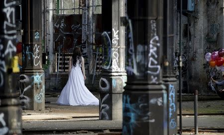 A woman walks during a photo shoot at an abandoned freight station in Pankow in Berlin March 9, 2015. REUTERS/Fabrizio Bensch