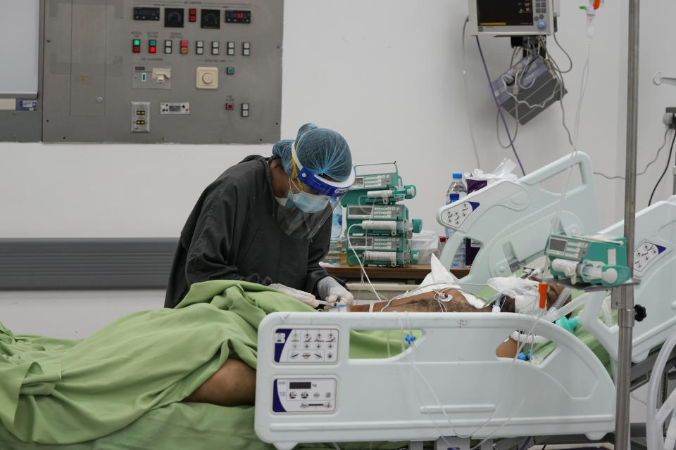 Medical staff assists with oxygen supply to a COVID-19 patient at the intensive care unit of the government-run Rafik Hariri University Hospital in Beirut, Lebanon, Saturday, Aug. 14, 2021. Many private hospitals, who offer 80% of Lebanon's medical services, are shutting down because of lack of resources or turning away patients who can't pay. (AP Photo/ Hassan Ammar)