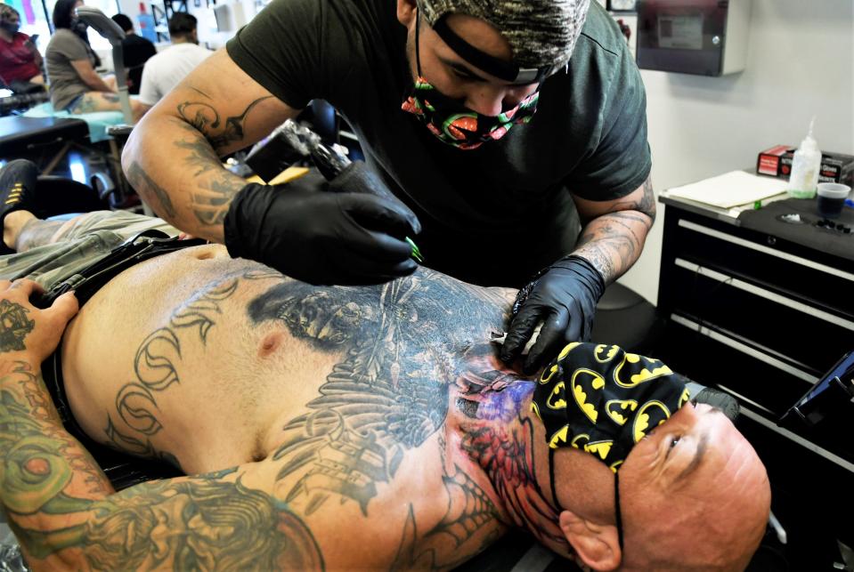 Joseph Cabello, owner of Tulare's Body Art Gallery, tattoos Doug Marshall on Friday, June 19, 2020.