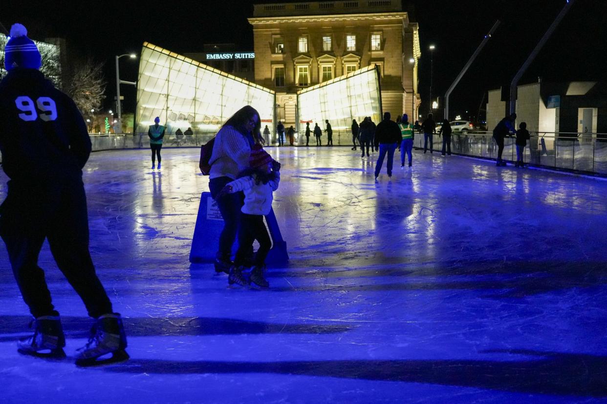 Emily Dikeman and Grace Dikeman, 5, center, ice skate at Brenton Skating Plaza on Tuesday, Dec. 12, 2023, in Des Moines.