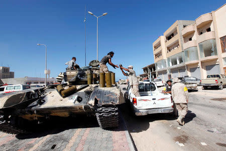 A fighter of Libyan forces allied with the U.N.-backed government receives ammunition for a tank near the eastern frontline of fighting with Islamic State militants, in Sirte, Libya, October 20, 2016. REUTERS/Ismail Zitouny