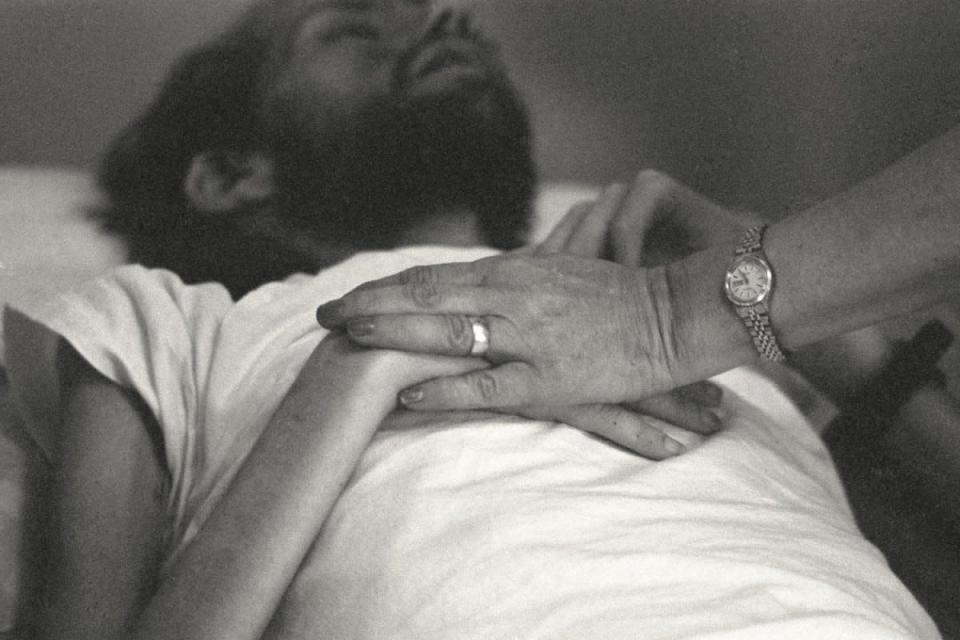 A nurse at Pater Noster House in Ohio holds David Kirby's hands not long before he died, spring 1990. (© Therese Frare) <br> <br> <a href="http://life.time.com/history/behind-the-picture-the-photo-that-changed-the-face-of-aids/#1" rel="nofollow noopener" target="_blank" data-ylk="slk:Click here to see the full collection at LIFE.com;elm:context_link;itc:0;sec:content-canvas" class="link ">Click here to see the full collection at LIFE.com</a>