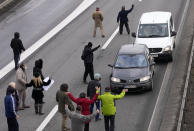 Environmental demonstrators block a highway during a protest in Belgrade, Serbia, Saturday, Jan. 15, 2022. Hundreds of environmental protesters demanding cancelation of any plans for lithium mining in Serbia took to the streets again, blocking roads and, for the first time, a border crossing. Traffic on the main highway north-south highway was halted on Saturday for more than one hour, along with several other roads throughout the country, including one on the border with Bosnia. (AP Photo/Darko Vojinovic)