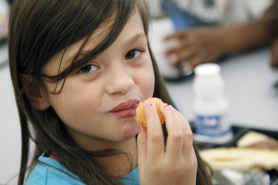 Nutrition is not on the mind of Eastside Elementary School fourth grader Grace Bethany when she chose her school lunch Wednesday, Sept. 12, 2012, in Clinton, Miss. What mattered, was the tartness of the plum that accompanied the flat bread roast beef sandwich. The leaner, greener school lunches served under new federal standards are getting mixed grades from students. (AP Photo/Rogelio V. Solis)