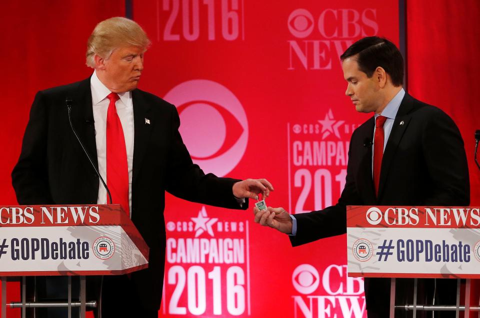 Republican presidential candidate, Sen. Marco Rubio, R-Fla., right, hands Republican presidential candidate, former President Donald Trump a tic tac container at a break during the CBS News Republican presidential debate at the Peace Center, Saturday, Feb. 13, 2016, in Greenville, S.C.