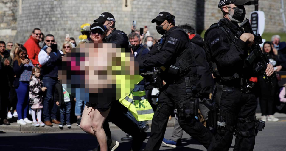 Topless woman outside Windsor Castle being arrested by police officers