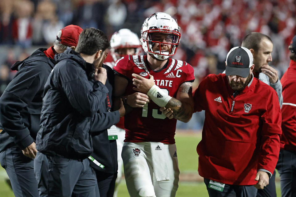 North Carolina State quarterback Devin Leary (13) is assisted off the field by medical staff during the second half of the team's NCAA college football game against Florida State in Raleigh, N.C., Saturday, Oct. 8, 2022. (AP Photo/Karl B DeBlaker)