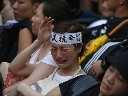 A protester wearing a headband which reads "civil disobedience" cries before being dragged away from a street by the police after staying overnight at Hong Kong's financial Central district July 2, 2014. REUTERS/Bobby Yip