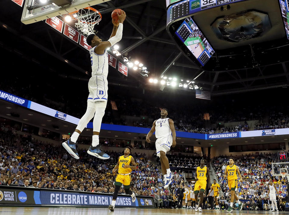 <p>RJ Barrett #5 of the Duke Blue Devils dunks the ball as teammate Zion Williamson #1 celebrates against the North Dakota State Bison in the second half during the first round of the 2019 NCAA Men’s Basketball Tournament at Colonial Life Arena on March 22, 2019 in Columbia, South Carolina. (Photo by Kevin C. Cox/Getty Images) </p>