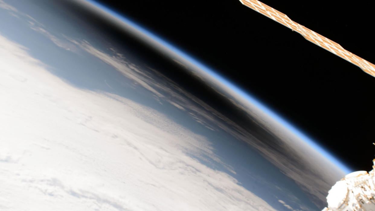  View of the dark shadow of a solar eclipse on earth, seen edge-on from orbit . 