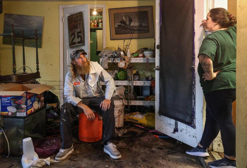 Shilo Carney, 35, left, and his wife Tara Hardy, 34, spent the day cleaning their home. The pair take a break from their clean-out after discarding the majority of their belongings. On Monday, April 17, 2023, less than a week after unrelenting rainfall flooded the streets of the Edgewood neighborhood in Fort Lauderdale, residents continued to clean out their soaked homes. Carl Juste/cjuste@miamiherald.com