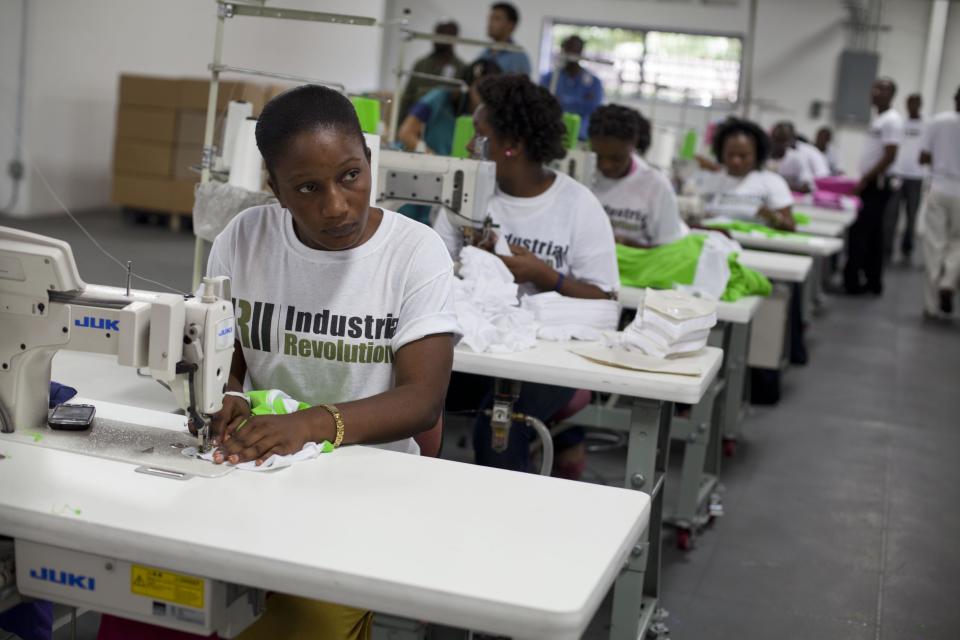 Workers labor at their stations during a visit by former U.S. President Bill Clinton to the new apparel manufacturer Industrial Revolution II, S.A. in Port-au-Prince, Haiti, Tuesday Feb. 18, 2014. Clinton visited the manufacturer, which plans to reinvest half its profits into a health care and education program. The former U.S. president is in a two-day trip to Haiti to visit several projects that focus on agriculture and the environment. (AP Photo/Dieu Nalio Chery)