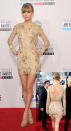 Taylor Swift makes a departure from her usual red-carpet look at the 2012 American Music Awards, wearing a nude-toned metallic minidress--an outfit that shows off the nearly 6 foot tall singer's rarely seen legs, as well as her back!