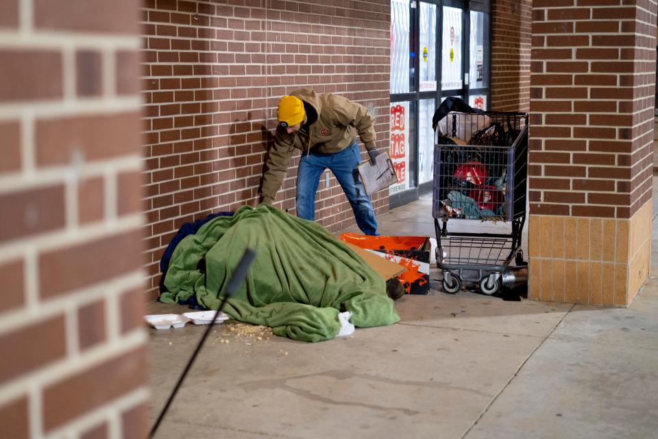 Cale Powers leaves a note with a person Thursday, Jan. 26, 2023, outside a store in northwest Oklahoma City during the Homeless Alliance's 2023 Point in Time count of the homeless population.