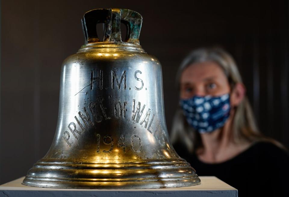 Victoria Ingles, senior curator at the National Museum of the Royal Navy, looks at the ship’s bell from HMS Prince of Wales which was sunk in the Second World War (Andrew Matthews/PA) (PA Wire)