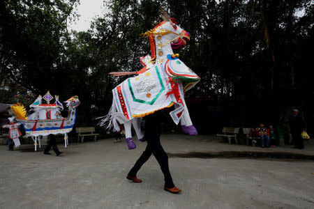 A man carries a paper horse which will be offered to saints before a ritual Hau Dong ceremony at Lanh Giang temple, in Ha Nam province, Vietnam, March 26, 2017. REUTERS/Kham