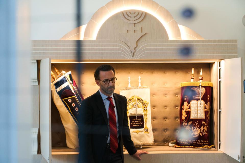 Ross Kriel, the president of the Jewish Council of the Emirates, speaks to The Associated Press in front of the community's Torahs in Dubai, United Arab Emirates, Sunday, Aug. 16, 2020. Telephone service between the United Arab Emirates and Israel began working Sunday as the two countries opened diplomatic ties, part of a deal brokered by the U.S. that required Israel to halt its contentious plan to annex West Bank land sought by the Palestinians for a future state. (AP Photo/Jon Gambrell)