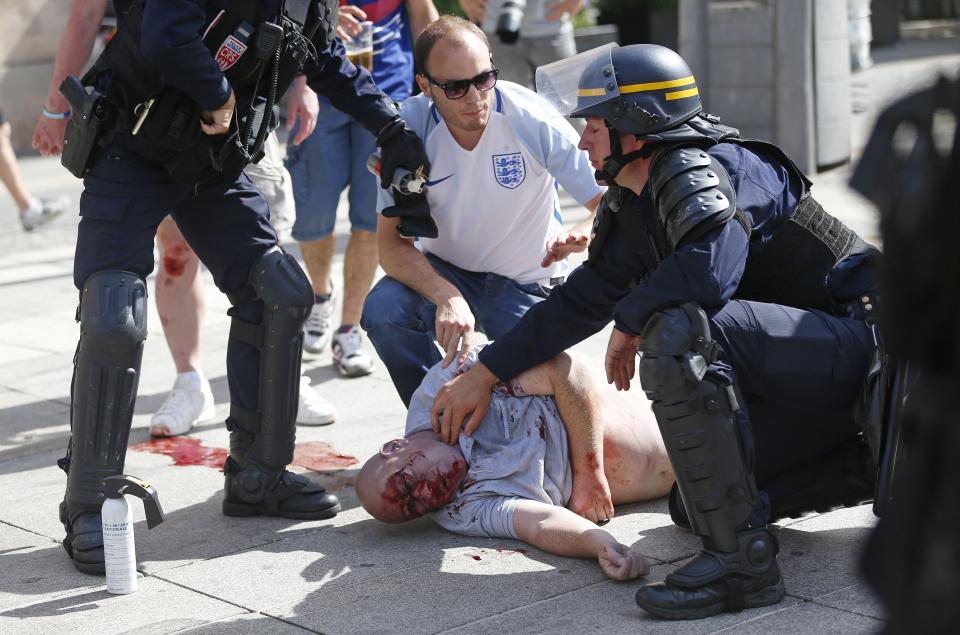 FILE - In this Saturday, June 11, 2016 file photo, a man injured in clashes is assisted by police officers in downtown Marseille, France. New FIFA secretary general Fatma Samoura says extra security measures are planned for the 2018 World Cup in Russia following hooligan violence at the European Championship. (AP Photo/Darko Bandic, File)