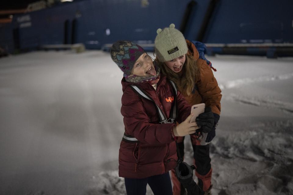 Children from Polargospel, the children's choir at the only church in Svalbard, take a selfie in front of the boat they traveled on upon arriving to Barentsburg, Norway, Saturday, Jan. 7, 2023. The choir traveled three hours each way by boat to mark Orthodox Christmas with the 40 children in Barentsburg, a village owned by Russia's Arctic mining company in the remote Norwegian territory. (AP Photo/Daniel Cole)