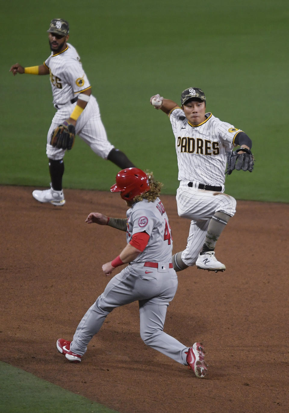 San Diego Padres shortstop Ha-Seong Kim (7) throws next to St. Louis Cardinals' Harrison Bader (48) as he turns a double play on Tommy Edman during the sixth inning of a baseball game Friday, May 14, 2021, in San Diego. (AP Photo/Denis Poroy)