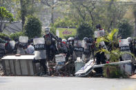 Myanmar riot police with shields cross the blockages set up by protesters during a protest against the military coup in Mandalay, Myanmar, Sunday, Feb. 28, 2021. Police fired tear gas and water cannons and there were reports of gunfire Sunday in Myanmar's largest city Yangon where another anti-coup protest was underway with scores of students and other demonstrators hauled away in police trucks. (AP Photo)