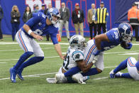 New York Giants quarterback Daniel Jones (8) watches as Carolina Panthers' Jeremy Chinn (21) tackles Devontae Booker (28) during the first half of an NFL football game, Sunday, Oct. 24, 2021, in East Rutherford, N.J. (AP Photo/Bill Kostroun)