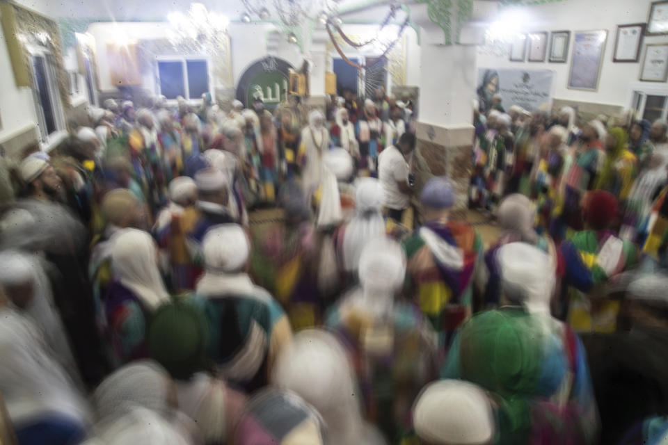 Members of the Sufi Karkariya order dance during a religious celebration to mark the prophet Muhammed's birthday, in Aroui, near Nador, eastern Morocco, Monday, Oct. 18, 2021. It was the first such gathering since the pandemic. The order, the Karkariya, follows a mystical form of Islam recognizable by its unique dress code: A modest yet colorful patchwork robe. (AP Photo/Mosa'ab Elshamy)