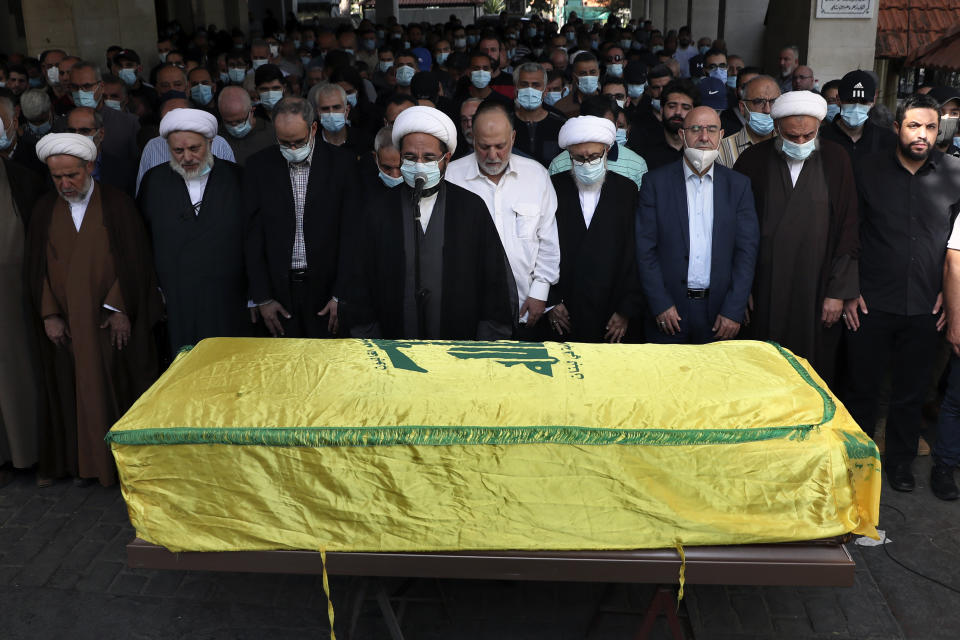 Relatives, friends and clergymen pray in front of the coffin of Ali Atwa, a senior Hezbollah operative, during his funeral procession in the southern Beirut suburb of Dahiyeh, Lebanon, Saturday, Oct. 9, 2021. Atwa was placed on the FBI's most wanted list in 2001, with two other alleged participants in the 1985 hijacking of TWA Flight 847, one of the worst hijackings in aviation history and that lasted for 16 days. (AP Photo/Bilal Hussein)