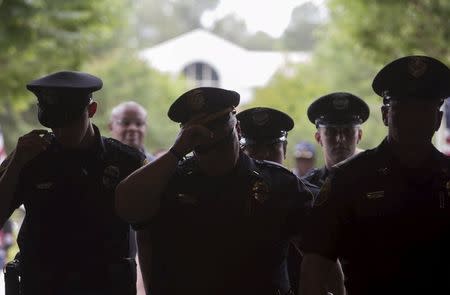 Policemen enter a building to attend a vigil service for two fellow officers killed during a traffic stop, in Hattiesburg, Mississippi May 11, 2015. REUTERS/Lee Celano