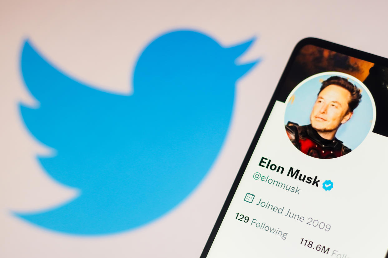 In this photo illustration, Elon Musk's Twitter account is displayed on a smartphone with the Twitter logo in the background.