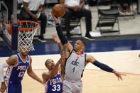 Washington Wizards guard Russell Westbrook (4) goes to the basket against Philadelphia 76ers guard George Hill (33) during the first half of Game 3 in a first-round NBA basketball playoff series, Saturday, May 29, 2021, in Washington. Hill was called for a foul the play. 76ers forward Tobias Harris (12) looks on. (AP Photo/Nick Wass)