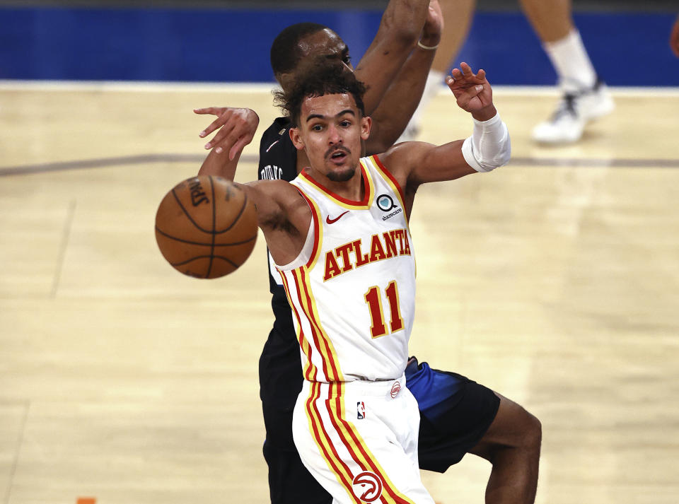 Atlanta Hawks' Trae Young (11) passes the ball as New York Knicks' Alec Burks defends during the fourth quarter in Game 2 in an NBA basketball first-round playoff series Wednesday, May 26, 2021, in New York. (Elsa/Pool Photo via AP)